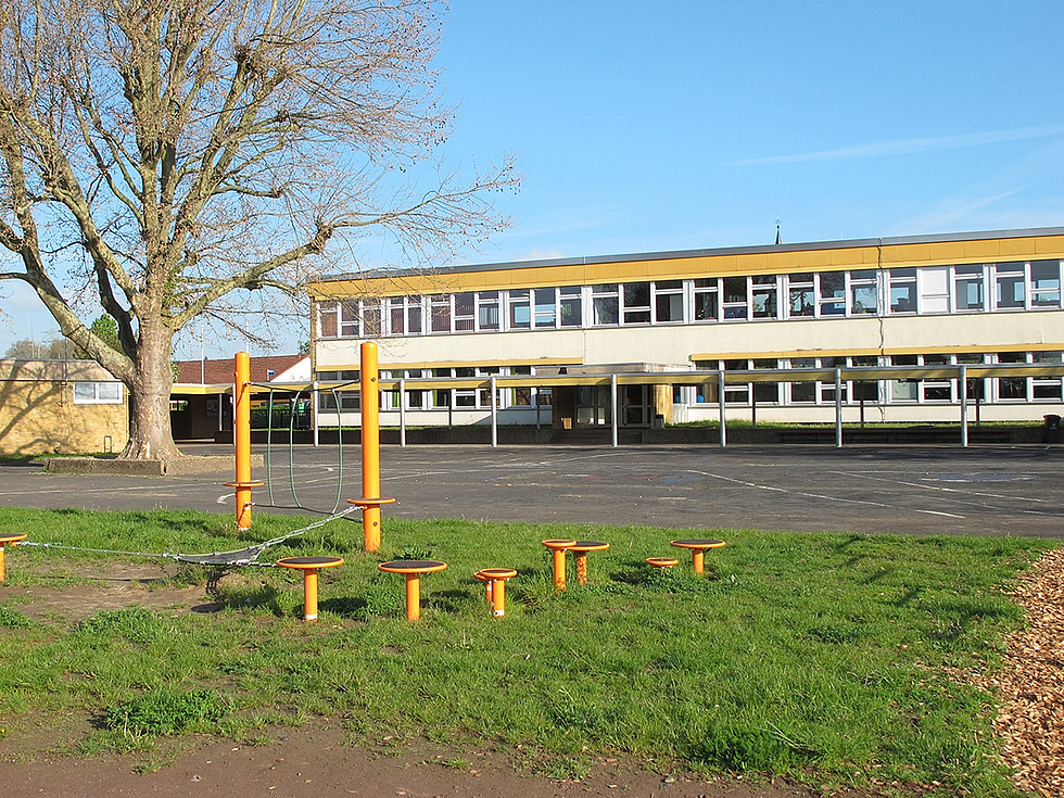 Schulgebäude der Johanniterschule, im Vordergrund der Spielplatz