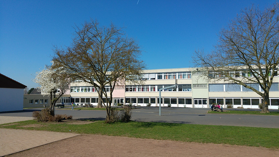 Schulgebäude, davor der Schulhof