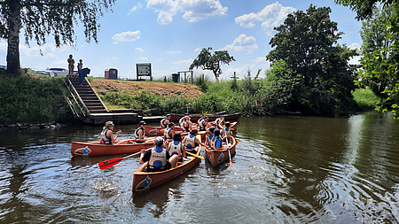 Jugendliche im Kanu auf einem Fluss