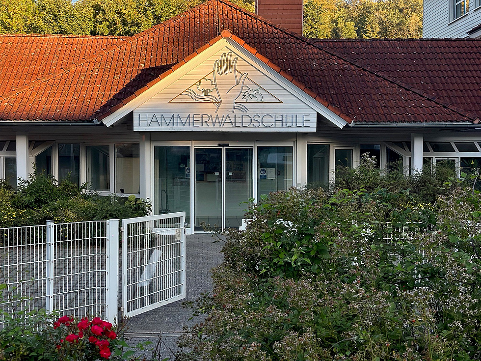 Eingang der Hammerwaldschule, über dem Eingang das Logo der Schule