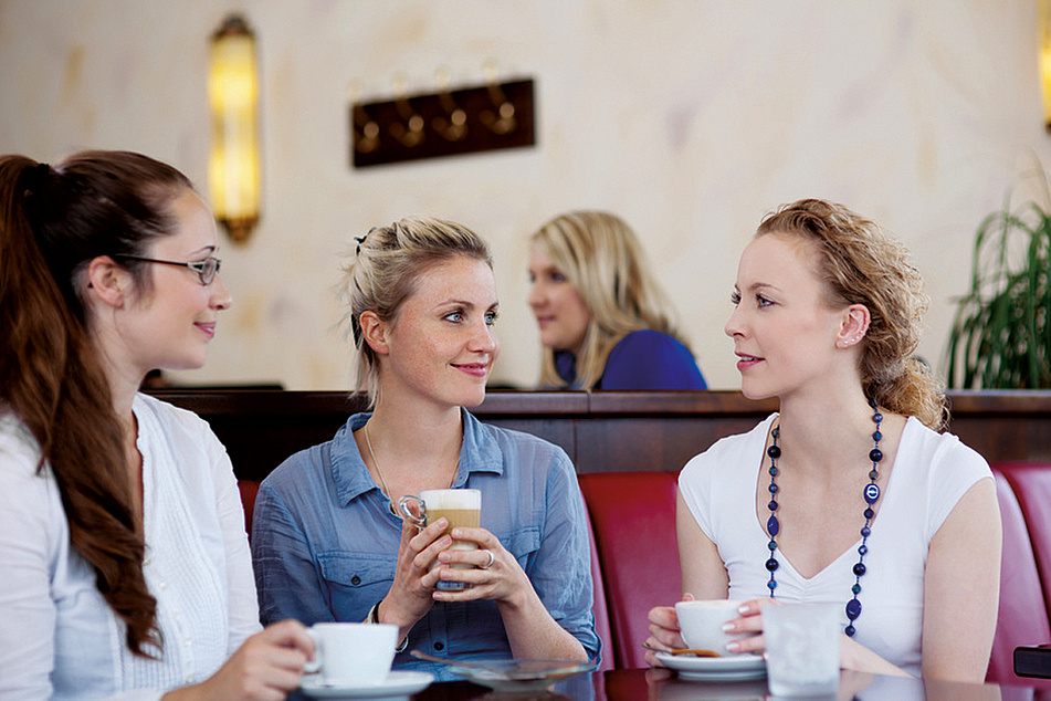 Drei Frauen trinken Kaffee und unterhalten sich
